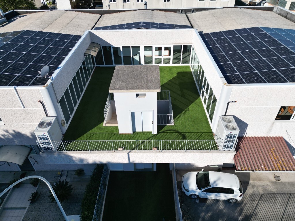 Veduta aerea della sede operativa Kalitek a Porto Sant’Elpidio, con terrazzo e coperture fotovoltaiche